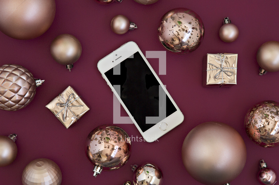 iPhone and gold ornaments on red 