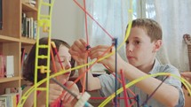 Boy and girl building a tower from toys at home