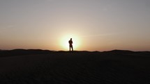 Silhouette of man in desert sunset.