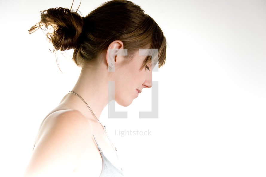 profile of a woman with her hair up looking down