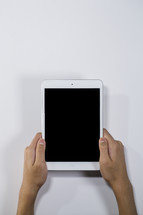 hands holding up an iPad 