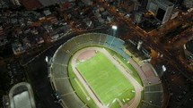 Aerial tilt-up of night view of the Atahualpa Olympic Stadium in Quito, Ecuador. 