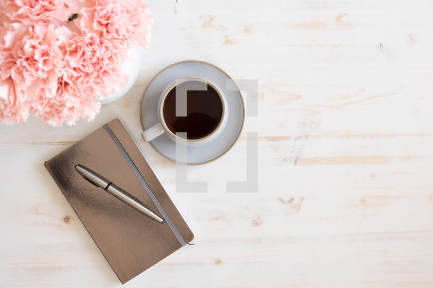 pink carnations, coffee cup, and journal 