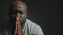 Hopeful Black Man Holding Hands Together and Praying to God Deeply