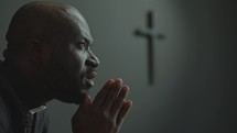 African American Priest Praying to God in Church