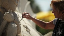 a man and woman carving a sand sculpture 