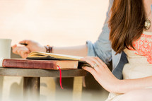young woman reading a Bible and journaling 