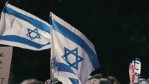 Demonstrators hold up the flag of Israel