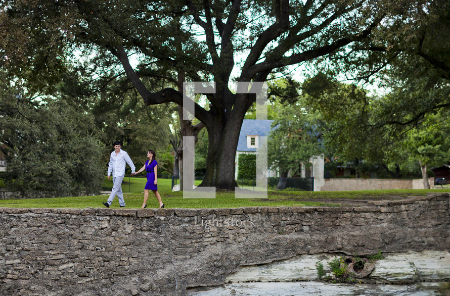 couple walking hand in hand on a neighborhood sidewalk