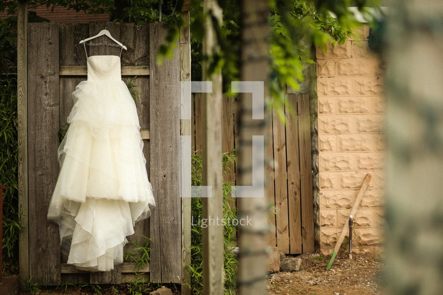wedding dress hanging on a door outside