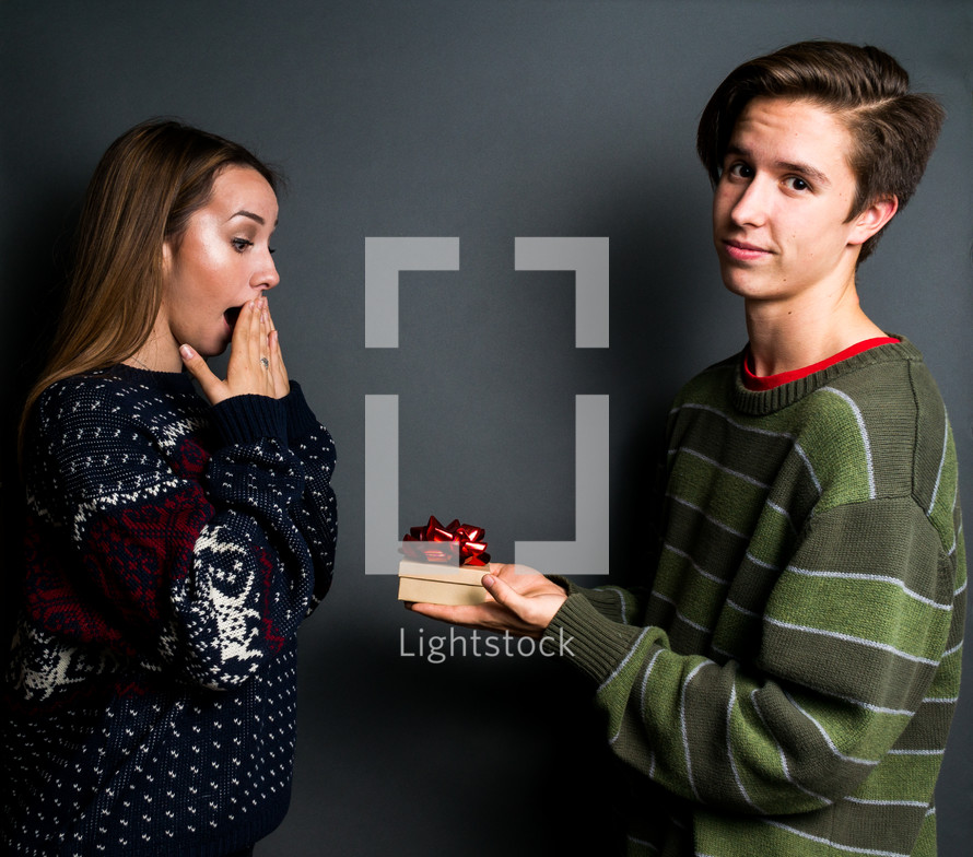 a young couple exchanging Christmas gifts 