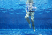 Low angle of businessman's legs underwater
