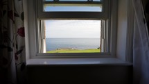 Looking through window out to sea from peaceful vacation home in summer