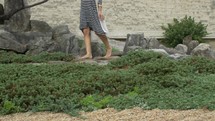 barefoot woman walks through rock garden- slider 