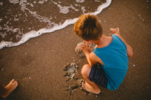a child playing in sand on a beach 