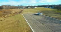 Small plane takes off on runway Aerial shot 