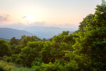 Hazy sunset over the mountains and green tree forest in West Virginia