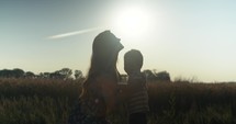 Silhouette of happy mother and son in sunset.