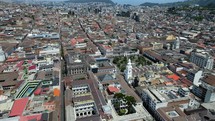 Aerial shot drone flies forward over main square in downtown Quito