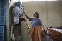 woman working with stacks of leather in a factory in Kenya 