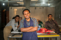 men in aprons in a factory making clothing 