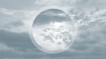 circle over clouds in sky, muted blue-green-gray
