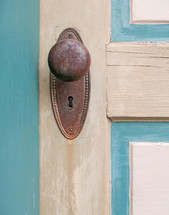 old painted door with rusted vintage knob and keyhole plate