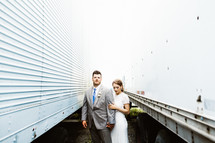 bride and groom standing between trucks 