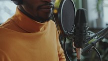 Close-Up of Man Speaking in Microphone as Recording Podcast at Studio
