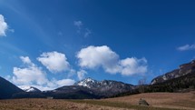Hilly rural alpine landscape, early spring, last remnants of snow on high mountain, timelapse