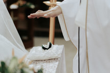 a priest blessing wedding rings 