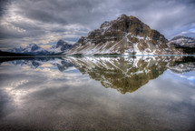 reflection of a mountain with snow on water 