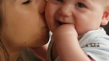Mother Kisses infant son- extreme close up 