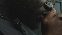 Close-Up View of Faithful Priest Praying Deeply in Church