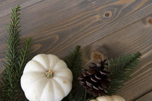 pumpkin and pine cone on wood background 