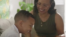 Latina mother and son spending time together playing on a tablet