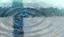 cross shadow in fountain with water drop and circular ripples
