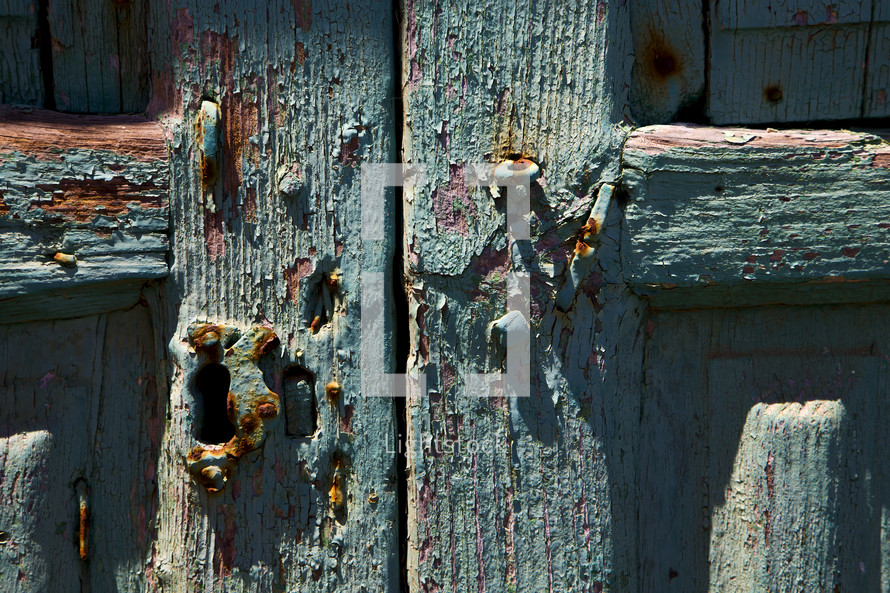 rusty door hinges oom a green wood door 