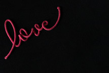 word love in rope on a black background 