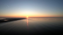 Aerial tracking drone shot of waves of Langeoog Island, Germany at the sunset.