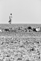 man walking across the desert in Ethiopia 