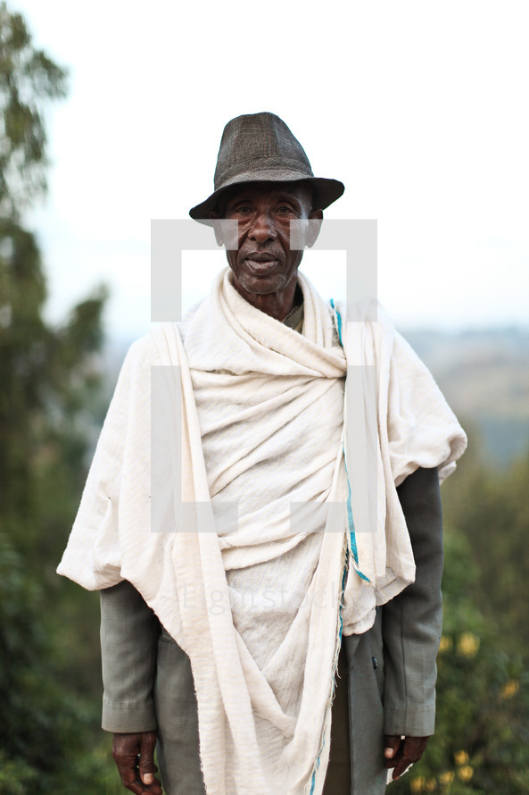 man wearing a hat and blanket