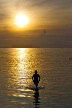 silhouette of a woman in the water of the Kho Phangan Bay at sunset 