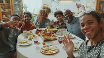 African American family looking at camera, happily smiling and waving while taking photos together on holiday dinner at home
