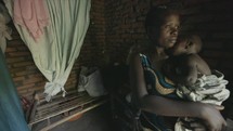 Young African mother cares for baby poverty 