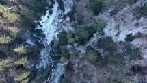 Above View Of High Forest Mountains With Frozen Stream In Winter. Aerial Drone