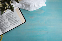 open Bible on a blue wood background 