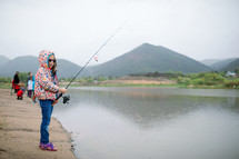 Little girl fishing at the lake 