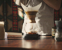 a man brewing coffee through a filter 