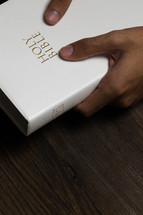 hand grasping a white Bible 